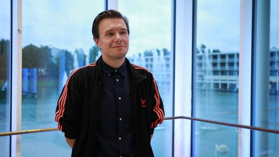 Elokuvaaja Jarmo Kiuru seisoo ikkunan edessä Tapiolan kulttuurikeskuksella